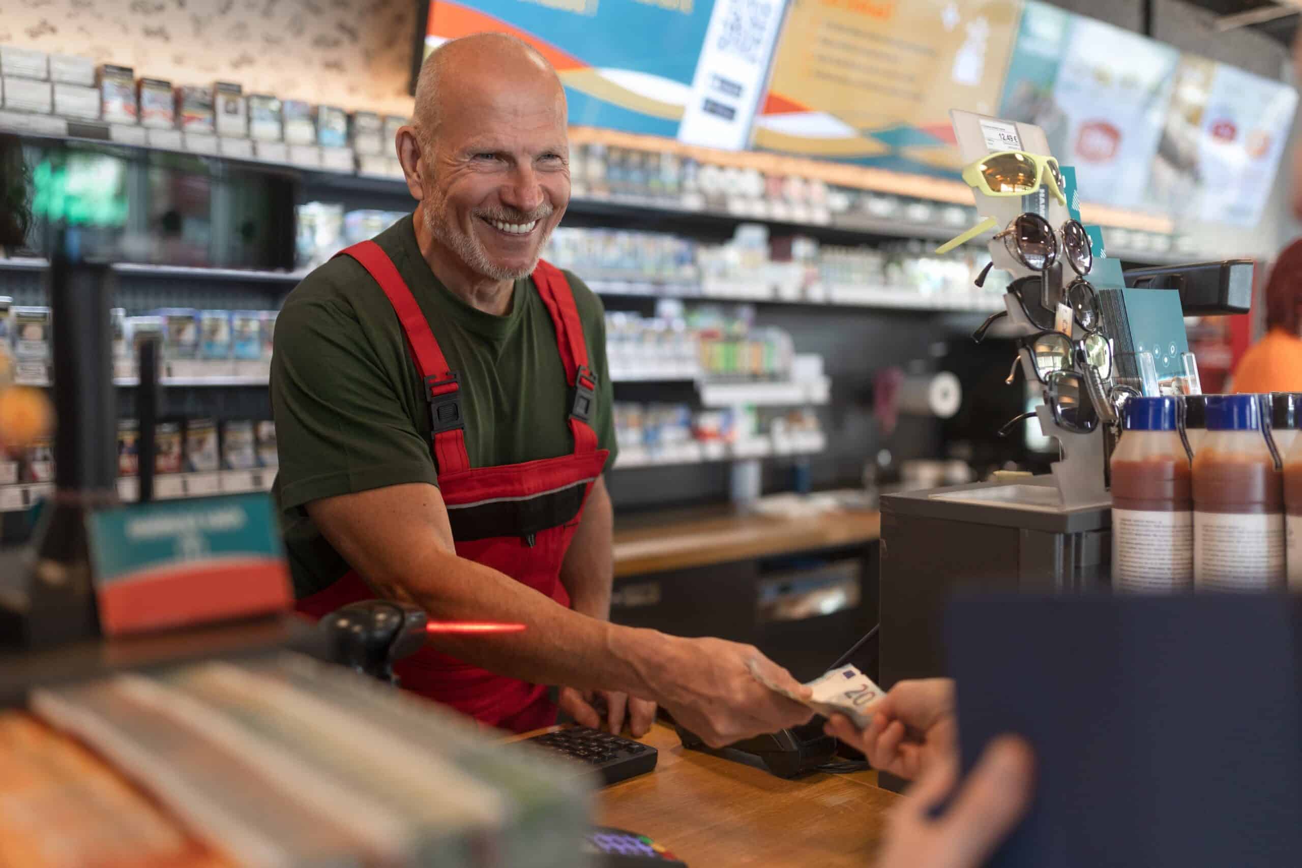 c-store_retail_employe c-store retail employee gives change to customer